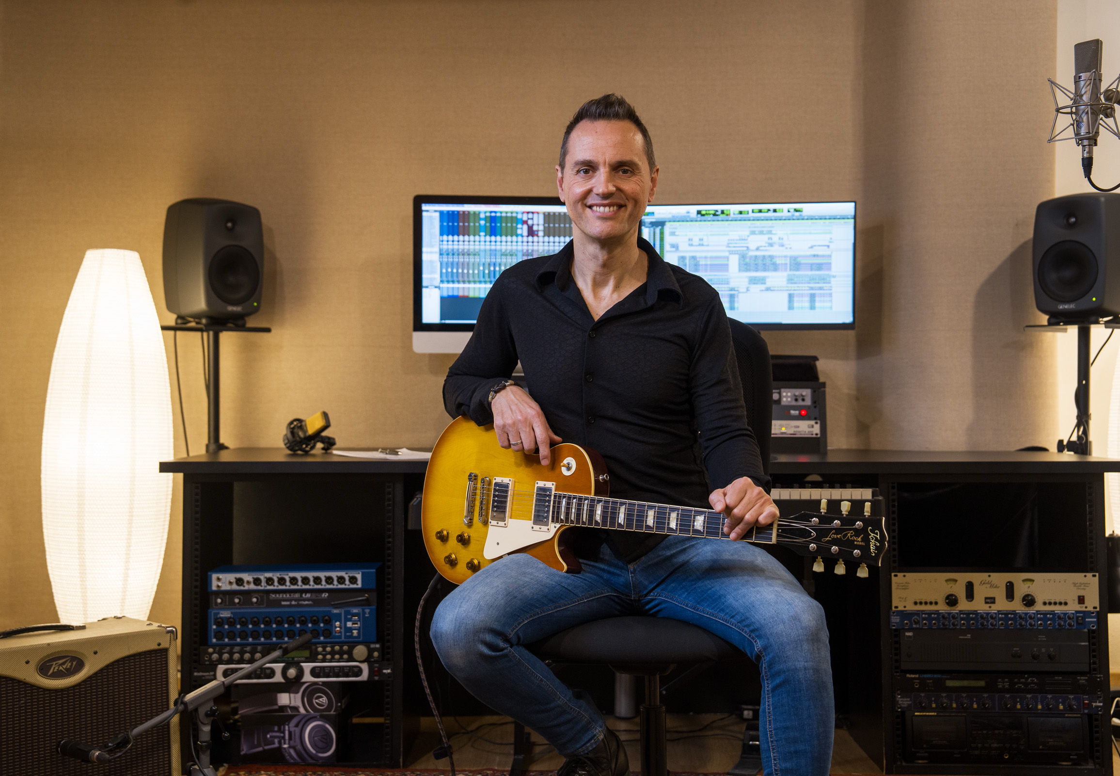 Pau sastre sosteniendo guitarra electrica en estudio de grabación